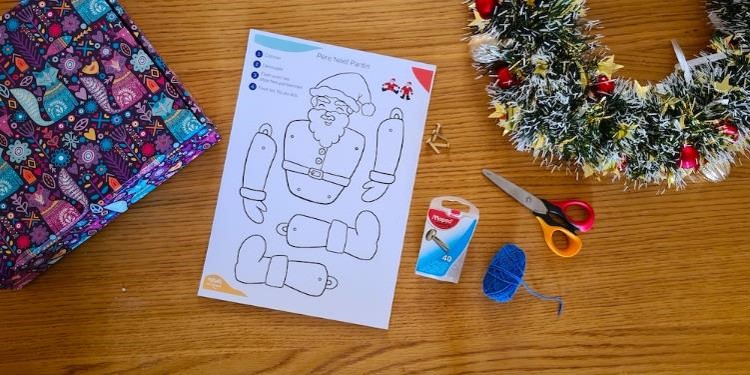 A printed page showing a Santa puppet template next to a pair of scissors