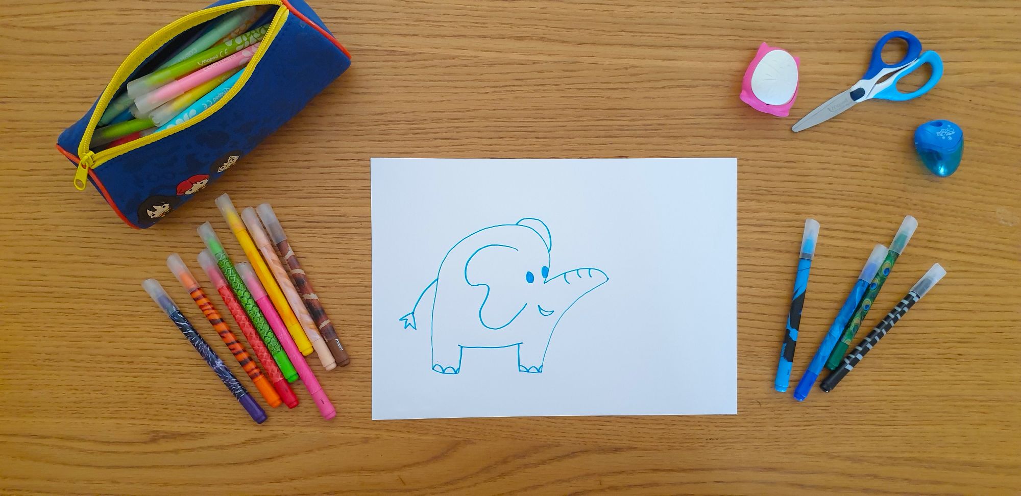 A picture of an elephant on a piece of paper laying on a desk