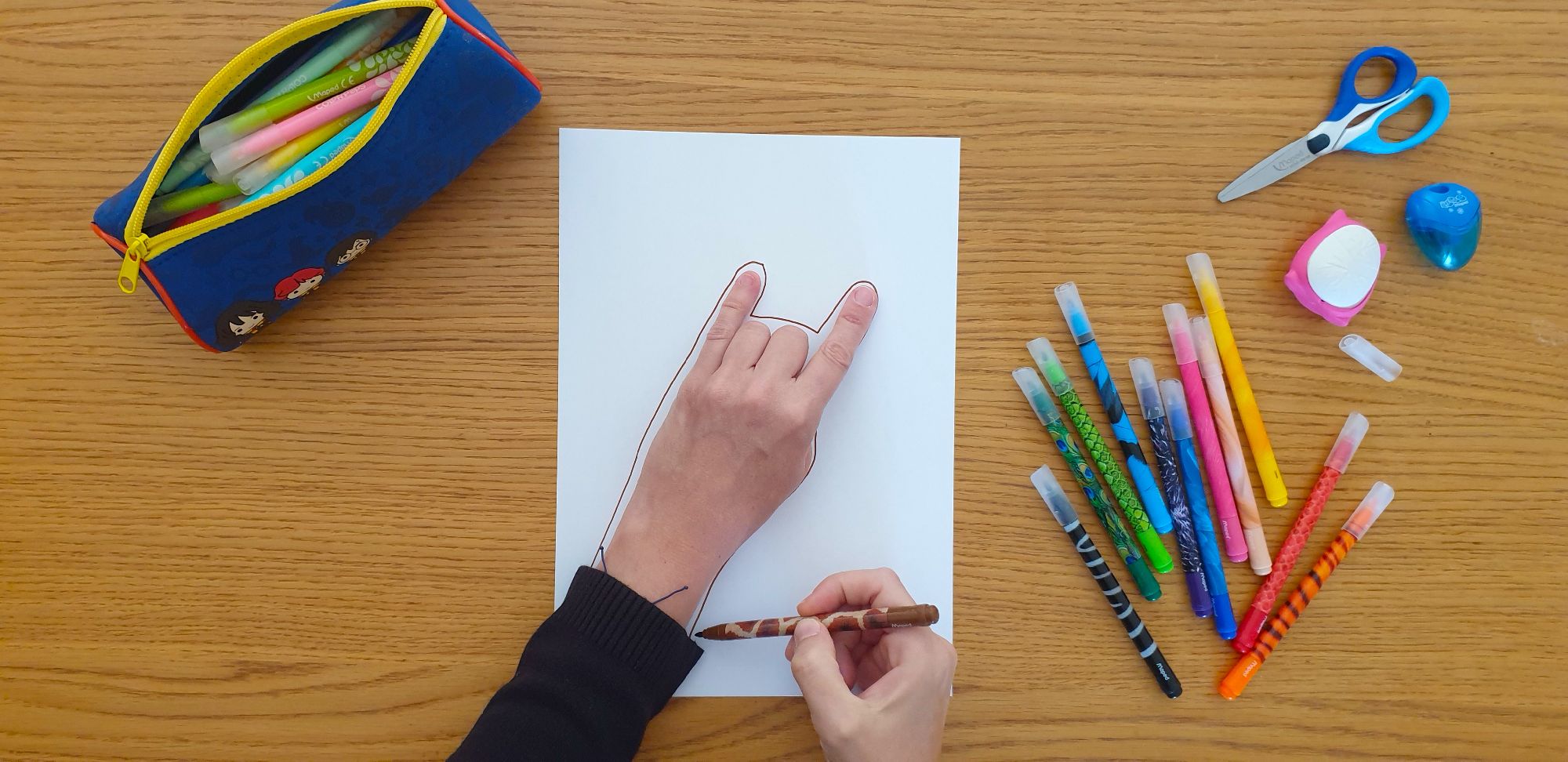 A picture of the outline of a giraffe's head on a piece of paper laying on a desk