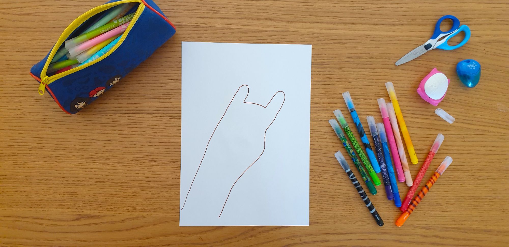 A picture of the outline of a giraffe's head on a piece of paper laying on a desk