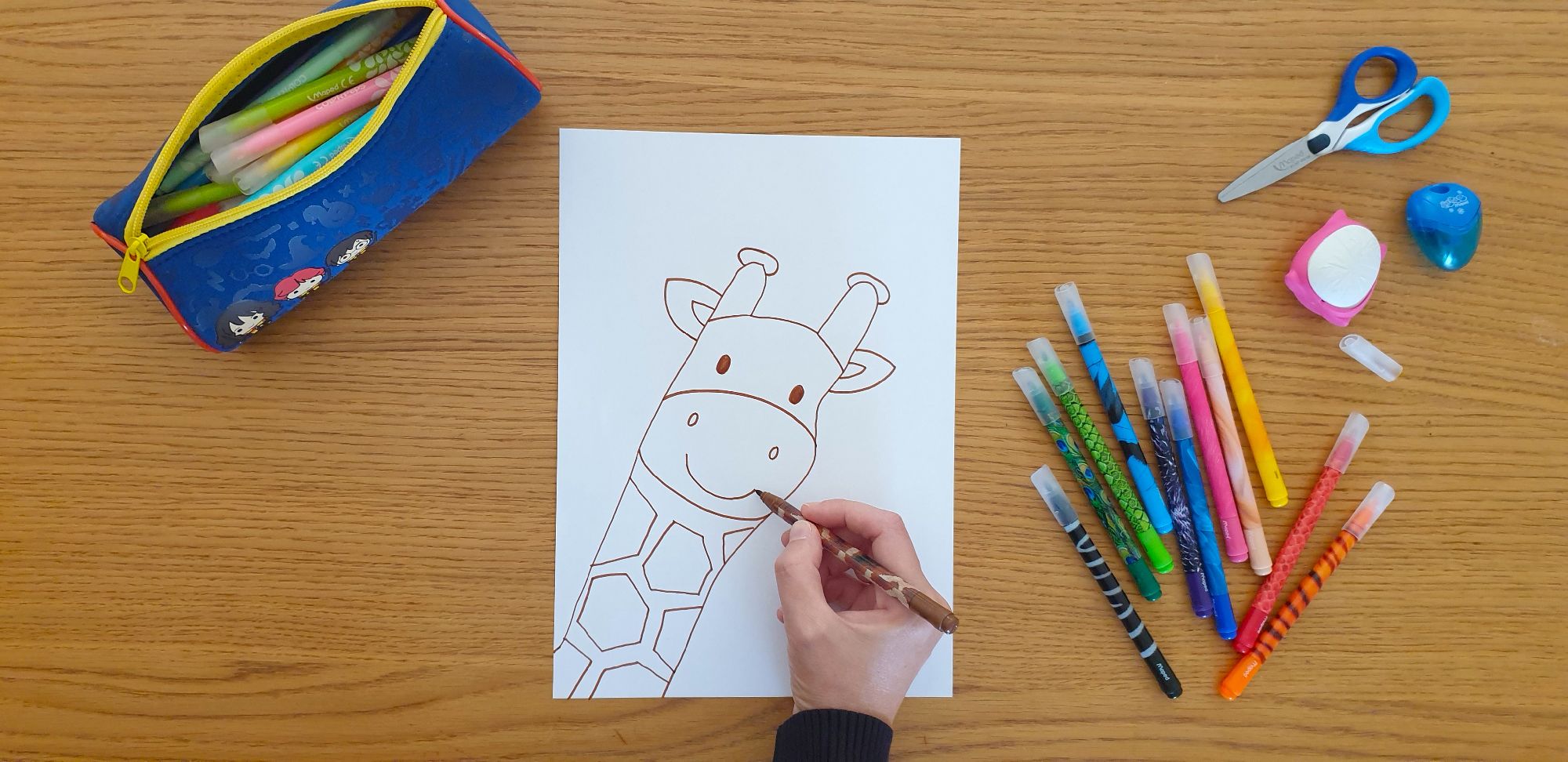 A picture of a giraffe's head on a piece of paper laying on a desk