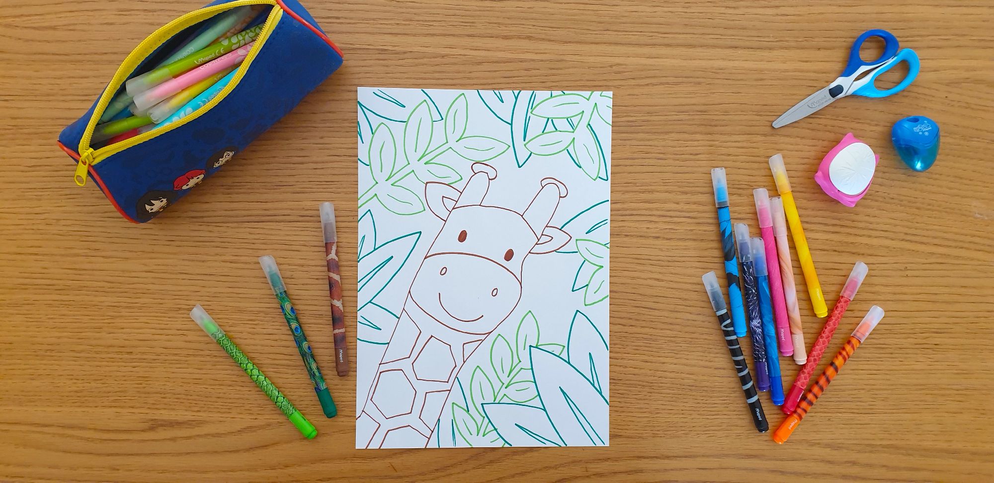 A picture of a giraffe's head on a piece of paper laying on a desk