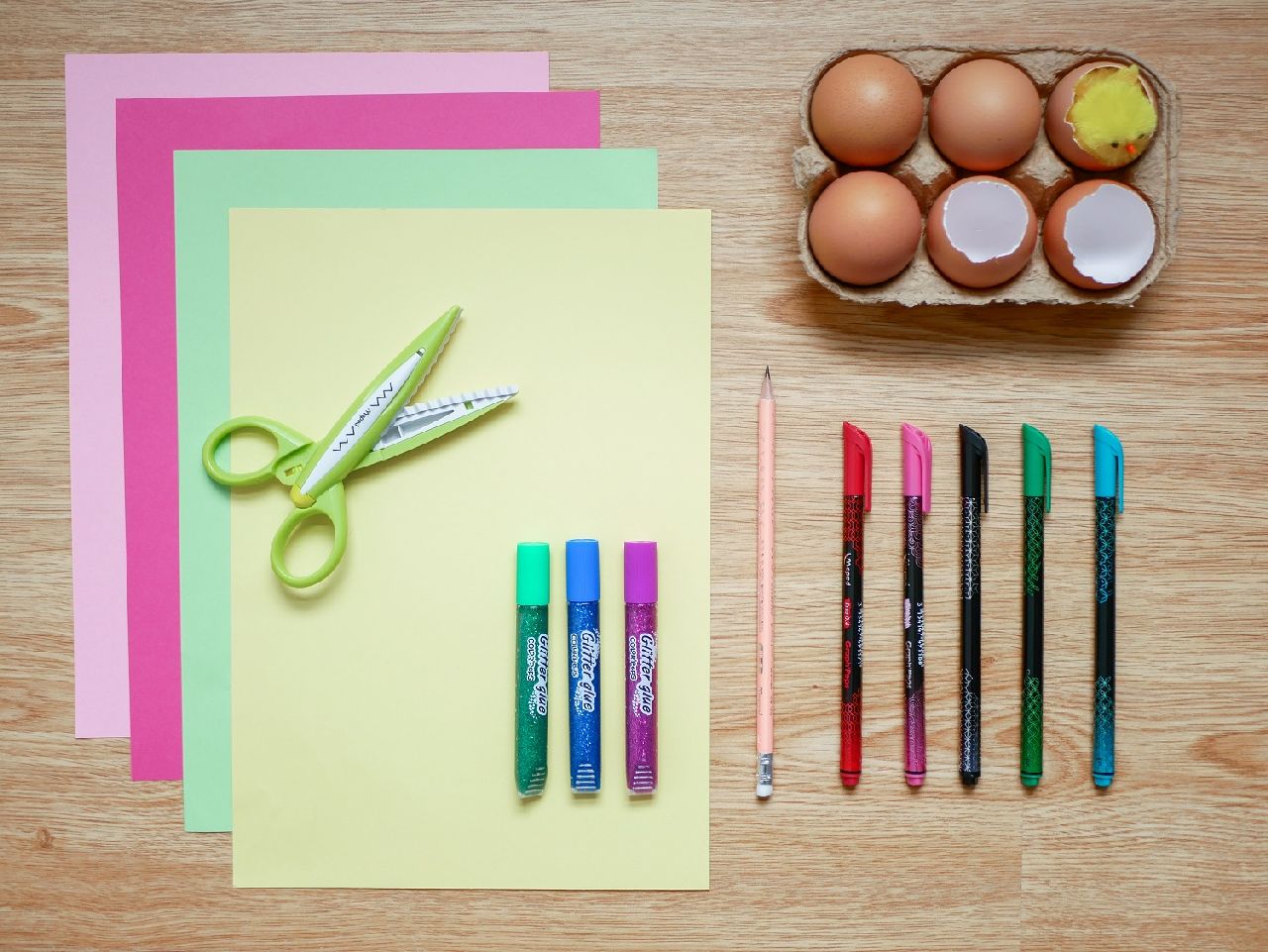 paper, pens and easter eggs lying on a desk